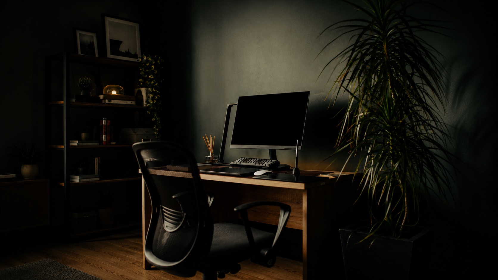 A lone computer on a desk in a quiet, dark room